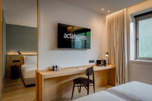 a hotel room with a desk and a bed at Acta The Clover in Porto