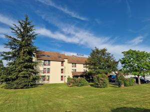 a large building with a tree in the yard at Kyriad Montluçon - Saint Victor in Saint-Victor