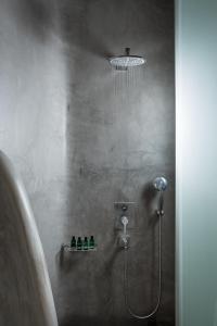a bathroom with a shower with a shower head at Colours of Mykonos Luxury Residences & Suites in Psarou