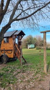 domek na drzewie ze zjeżdżalnią obok drzewa w obiekcie Los furgones de Areco w mieście San Antonio de Areco