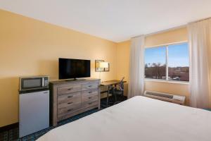 a hotel room with a bed and a television at SureStay Plus Hotel by Best Western Minot in Minot