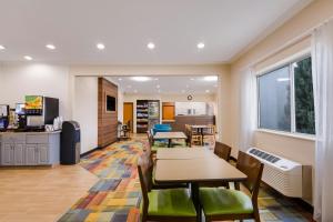 a dining room with tables and chairs and a kitchen at SureStay Plus Hotel by Best Western Minot in Minot