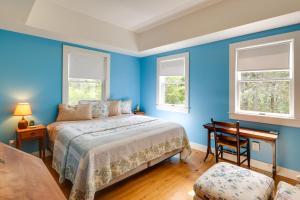 a blue bedroom with a bed and two windows at Enchanting Retreat in Prospect Harbor in Prospect Harbor