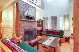 a living room with a fireplace and a green couch at Enchanting Retreat in Prospect Harbor in Prospect Harbor