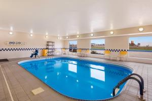 a large swimming pool in a hotel room at SureStay Plus Hotel by Best Western Minot in Minot