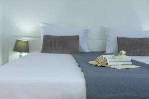 a bed with a tray of towels and a book on it at Apartments Pasalic in Kaštela
