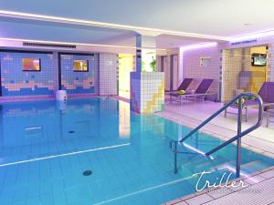 una gran piscina con azulejos azules en el suelo en Stay by Triller - Aparthotel & Pool en Saarbrücken