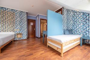 1 dormitorio con 2 camas y pared azul en Hotel Puerto de Candás, en Candás