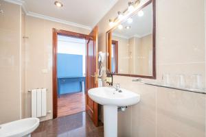 La salle de bains est pourvue d'un lavabo et d'un miroir. dans l'établissement Hotel Puerto de Candás, à Candás