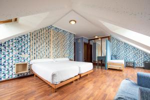 1 dormitorio con 1 cama y una pared azul y blanca en Hotel Puerto de Candás, en Candás