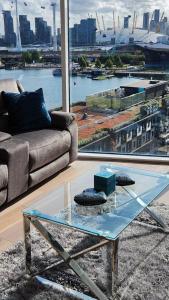een woonkamer met een bank en een glazen tafel bij Luxury 2 Bed Apartment EXCEL London in Londen