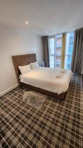een slaapkamer met een groot bed en een groot raam bij Luxury 2 Bed Apartment EXCEL London in Londen
