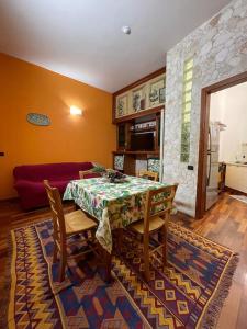 a dining room with a table and chairs and a couch at Casa Elle in Catania