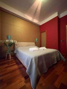 a bedroom with a white bed and a red wall at Casa Elle in Catania