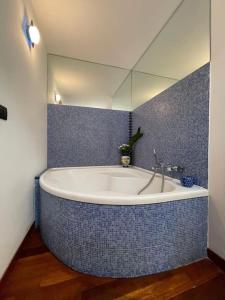 uma casa de banho com uma banheira grande e um espelho. em Casa Elle em Catânia