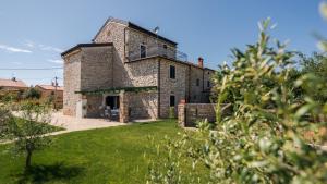 an old stone house with a green yard at Villa Francesca by Villas Holiday in Umag