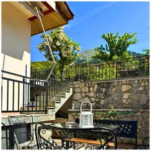 eine Terrasse mit einem Tisch, Stühlen und Treppen in der Unterkunft Memories Apartments Μονοκατοικία στο Καρπενήσι in Karpenisi