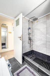 a bathroom with a shower with a glass door at Koukaki Apartment in Athens