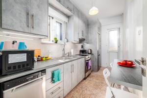 a kitchen with white cabinets and a counter top at Koukaki Apartment in Athens