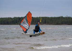 un hombre está haciendo windsurf en un cuerpo de agua en Hammarö Vandrarhem, en Hammarö