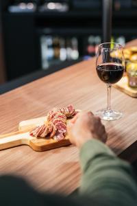 una copa de vino junto a una tabla de cortar con carne en Mercure Brest Centre Port en Brest