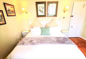 um quarto com uma grande cama branca e 2 almofadas em Gateside Guesthouse em Hilton