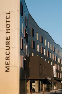 un bâtiment avec un panneau sur son côté dans l'établissement Mercure Brest Centre Port, à Brest