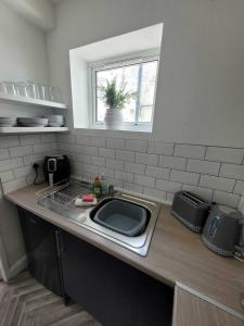 encimera de cocina con fregadero y ventana en Blackpool Abode - Sunny Suite Apartment, en Blackpool