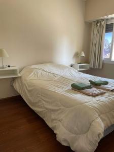 a bed in a bedroom with two towels on it at Departamento centrico con cochera incluida in Bahía Blanca