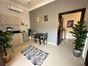 Smart Entry Apartment w Pvt Entrance في الرياض: غرفة معيشة مع طاولة ومطبخ