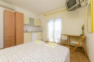 a bedroom with a bed and a desk and a tv at Apartment Radojka in Bol
