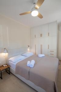 1 dormitorio con 2 camas y ventilador de techo en Stoupa Harmony Suite - One Bedroom Apartment, en Stoupa