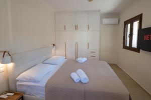 1 dormitorio con 2 almohadas blancas en una cama en Stoupa Harmony Suite - One Bedroom Apartment, en Stoupa