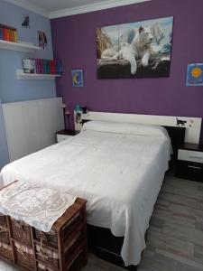 1 dormitorio con cama blanca y paredes moradas en Vacaciones en Marbella, en Marbella