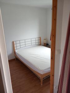 a small bedroom with a bed with white sheets at Hameau 8 102 - SPA & PISCINE appartement 4 pers in Orelle