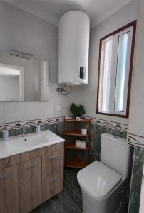une salle de bain avec toilettes, lavabo et miroir dans l'établissement Alójate en el corazón de Vigo, à Vigo