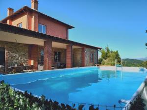 a large swimming pool in front of a house at Ala Ovest de La Fabbrica in collina in Prasco