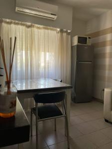 a kitchen with a table and a chair and a refrigerator at Departamento centrico con cochera incluida in Bahía Blanca