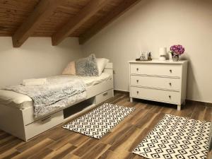 - une chambre avec un lit, une commode et un tapis dans l'établissement House Marija, à Orašac