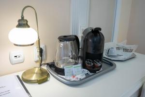 a tray with a coffee maker on a table next to a lamp at Villa Alice in Suceava