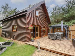 a cabin with a wooden deck with a patio at Little Lodge in Kings Lynn