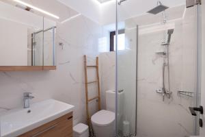 y baño con ducha, aseo y lavamanos. en Stoupa Harmony Suite - One Bedroom Apartment, en Stoupa