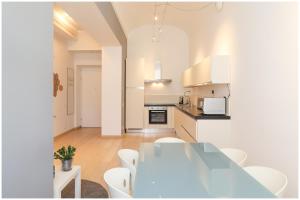 - une cuisine et une salle à manger avec une table et des chaises dans l'établissement Casa San Carlo nel cuore di Torino, à Turin