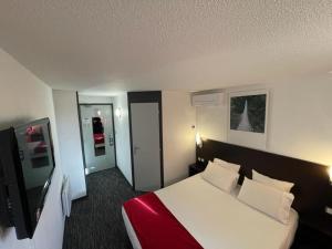 a hotel room with a bed and a tv at Kyriad Montluçon - Saint Victor in Saint-Victor