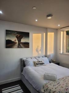 - une chambre dotée d'un grand lit avec une photo sur le mur dans l'établissement Astral 1 BR Flat in London AS36, à Norbury