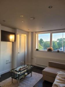 a living room with a couch and a table and a window at Astral 1 BR Flat in London AS36 in Norbury