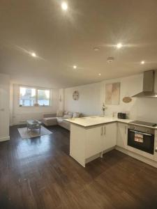 a kitchen and living room with a couch in the background at Astral 1 BR Flat in London AS36 in Norbury