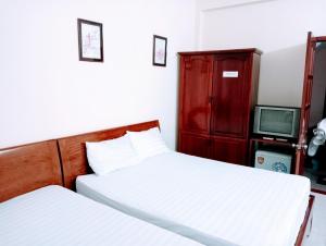 a bedroom with two beds and a red cabinet at Quân Nguyễn in Vung Tau