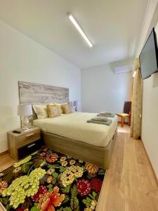a bedroom with a bed and a television in it at APART Casas Brancas in Vila Viçosa