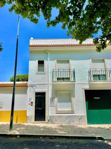 a white building with two balconies on it at APART Casas Brancas in Vila Viçosa